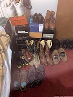 Photo showing a variety of men's shoes including white Nike Air tennis shoes, brown leather cowboy boots, lace-up dress shoes, and casual slip-on shoes, some in original boxes