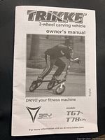 Front cover of the Trikke owner's manual showing a person riding the 3-wheel carving vehicle. Includes Trikke branding and model numbers T67 and T78.