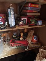 Shelf with vintage toys including red cable car, green tractor, board games, bowling pin, and other assorted collectibles.
