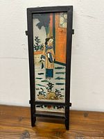 Frontal view of the Chinese handpainted glass painting mounted in a wooden frame, showing the woman, dogs, and background details.