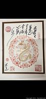Straight-on view of framed dragon print with calligraphy and stamps showing intricate gold and red design, and measurements approx 36cm by 28cm.