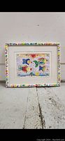 Photo of framed watercolor painting showing four colorful fish and decorative frame