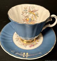 Close-up view of Royal Grafton Prussian blue teacup exterior with fluted design and gold accents on rim and base.