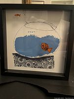 Front view of square framed art print featuring simple fishbowl and orange goldfish on glass surface.