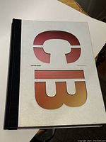 Front cover of the hardcover book showing gradient letters 'CB' on a white background with a black spine.