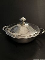 Front view of covered tureen showing scalloped edge, lid and handles