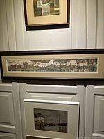 Full view of the framed panoramic print showing historical Amsterdam cityscape hanging on a wall.
