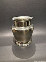 Full view of the pewter vase showing its rounded body and flared rim.