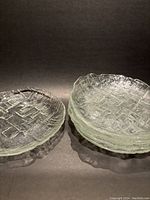 Set of six glass salad plates stacked together showing the textured Kris Kross pattern and wavy edges in clear heavy glass.