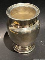 Front angle photo showing the rounded body and flared top rim of the silver plate vase with some surface tarnish.