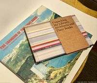Two architectural books photographed on a marble surface, one stacked on the other.