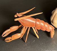 Close-up of wooden lobster showing articulated limbs and claw details