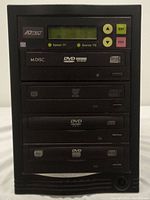 Photo of Adtec 3-tray DVD duplicator tower with LCD display, control buttons, and 3 DVD writer trays visible