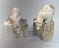 Two hand carved stone bear figurines shown from front angle, highlighting their shape and base structure.