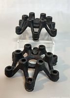 Front angled photo showing two black cast iron candle holders with spider-like design and seven tapered candle sockets each.