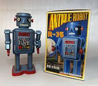 Front view of the blue mechanical walking robot with box showing the colorful graphics of 'Antique Robot R-35'.