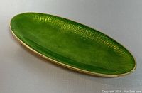 Oval green guilloche enamel interior with visible textured pattern and sterling silver rim