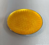 Top view of the small oval dish showing yellow guilloche enamel with crisscross pattern.