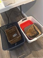 Photo showing a group of baskets including 3 plastic baskets (white, grey, red) and 4 woven baskets with handles placed inside and outside plastic baskets.