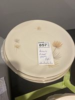 Stack of Heinrich dinner plates showing floral pattern and gold rim.