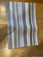 Single blue and white striped placemat laid flat showing pattern and texture.