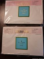 Two unopened Kate Spade New York telegram-style notepads stacked, showing front of packages with logo and telegram design.