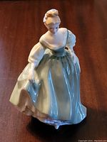 Front and side view showing detailed dress and posture of the Royal Doulton figurine.