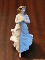 Front view of Royal Doulton Forget Me Not HN 3388 figurine showing the woman in a flowing dress holding flowers.