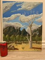Front view of the oil painting showing the landscape with tree, mountains, and sky.