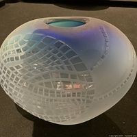 Side view of iridescent blown glass vase showing blue and purple hues with etched grid pattern.