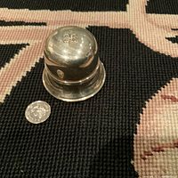 Silver-tone vintage dome-shaped ring box with 'BB' logo on top, shown closed next to a coin for scale.