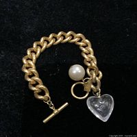 Photo of the full bracelet laid out showing chain links, toggle clasp, faux pearl charm, and acrylic heart charm.