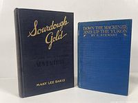 Front covers of two hardcover books about Yukon adventures, 'Sourdough Gold' and 'Down The Mackenzie River and Up The Yukon'