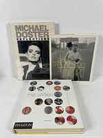 Three hardcover vintage fashion books displayed upright: The Sixties (bottom), Rico Puhlmann: A Fashion Legacy (middle), Michael Doster: Reflections (top).