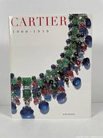 Front cover of Cartier 1900-1939 book showing large colorful gemstone necklace.