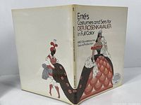 Front and back cover of the hardcover clothbound book showing title and artwork of costumes for Der Rosenkavalier.