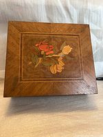 Top view of the antique wooden box with floral inlay decoration on the lid.