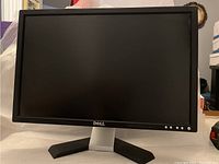 Front view of Dell computer monitor, showing black frame, screen, and lower bezel with Dell logo and control buttons.