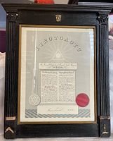 Photo of entire framed certificate showing wooden frame with minor damage and certificate with red seal and signature.