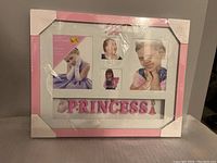Rectangular multi-photo frame with pink border and white matting, displays child's photos and 'PRINCESS' text.