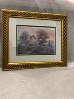 Front view of the framed print painting showing a house and landscape scene in a decorative gold frame.