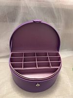 Front open view of the purple jewelry box showing the multiple compartment inserts inside for organizing jewelry.