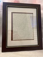 Front view of the dark brown wooden photo frame with gold accent and mat for 8x10 photo.