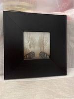 Black wooden square picture frame with a central photo of a foggy bridge scene.