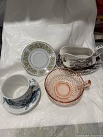 Front view of cups, saucers, and gravy bowl showing patterns and materials