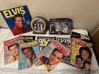 Full view of Elvis Presley magazines, PEZ dispenser set in circular package, and Tommy Elvis Barbie set in rectangular box