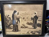 Front view of the framed picture showing the three figures and the desert scene.