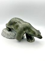 Side front view of green-gray soapstone carved polar bear on textured base showing overall size and carved details
