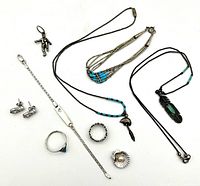 Overview of all 9 sterling silver pieces included in the lot, showing various necklaces, pendants, ring, earrings, and bracelets.