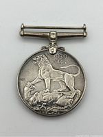Reverse view of sterling silver World War 2 medal with lion and eagle design and date 1939-1945.